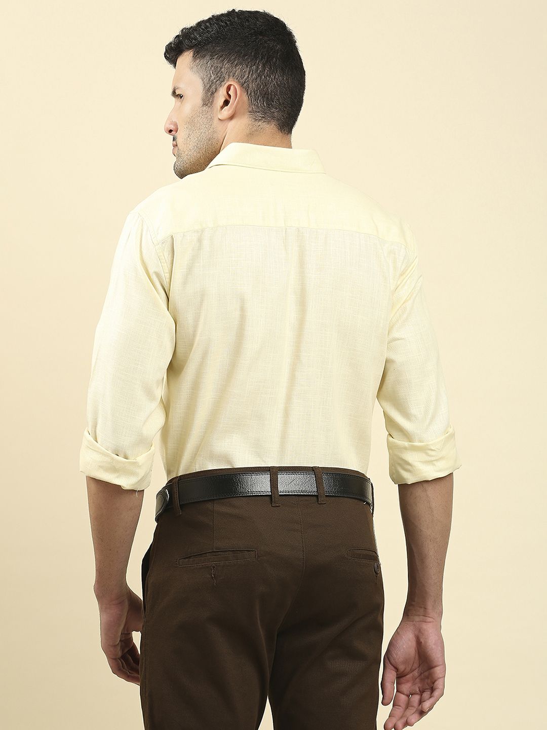 a young man wearing a gray shirt and khaki pants Stock Photo by Icons8